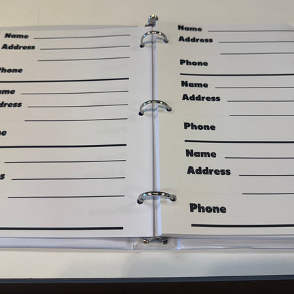 Large print address book for low vision open to pages with spaces for names and phone numbers.