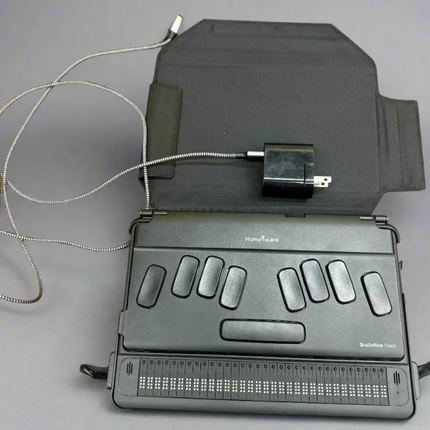 used BrailleNote Touch 32 Plus Braille note taker tablet with 32-cell Braille display, charger, and protective case on gray background