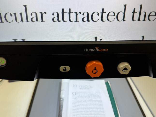 Close-up of used Reveal 16 video magnifier controls displaying large text.