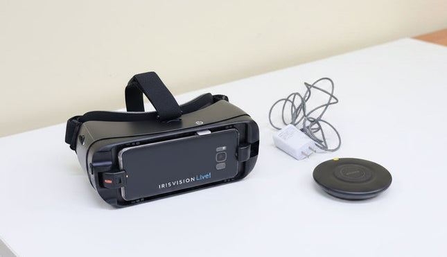 Black VR headset with 'IrisVisionLive!' branding on a wooden surface, accompanied by a power adapter and cable.