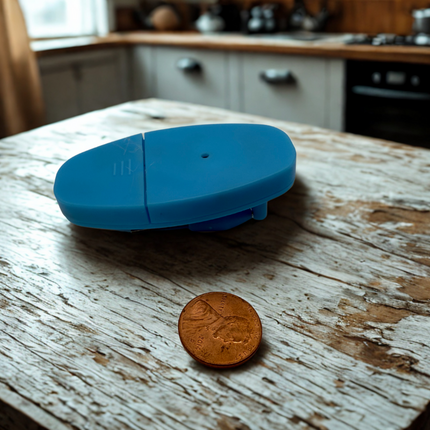 Liquid level indicator with sensors placed on a wooden table next to a coin, showcasing its design and size.