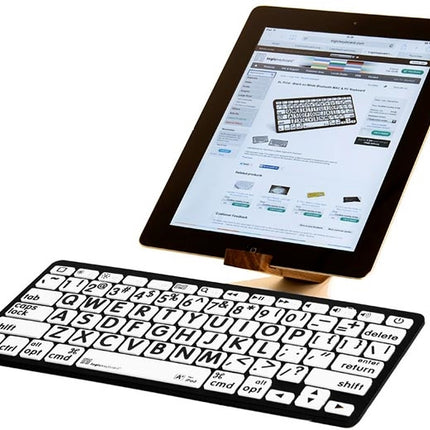 Large print Bluetooth keyboard for Mac next to an iPad displaying a website on the screen.
