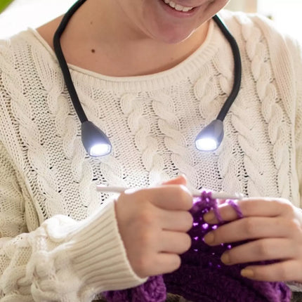 Person using a flexible neck light while crocheting, showcasing its hands-free design and bright LED illumination.