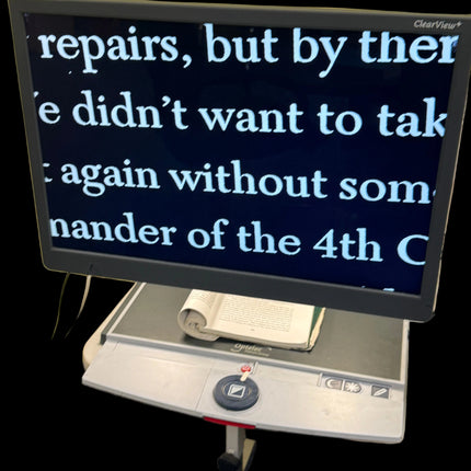 Monitor displaying text on a desk with a book underneath