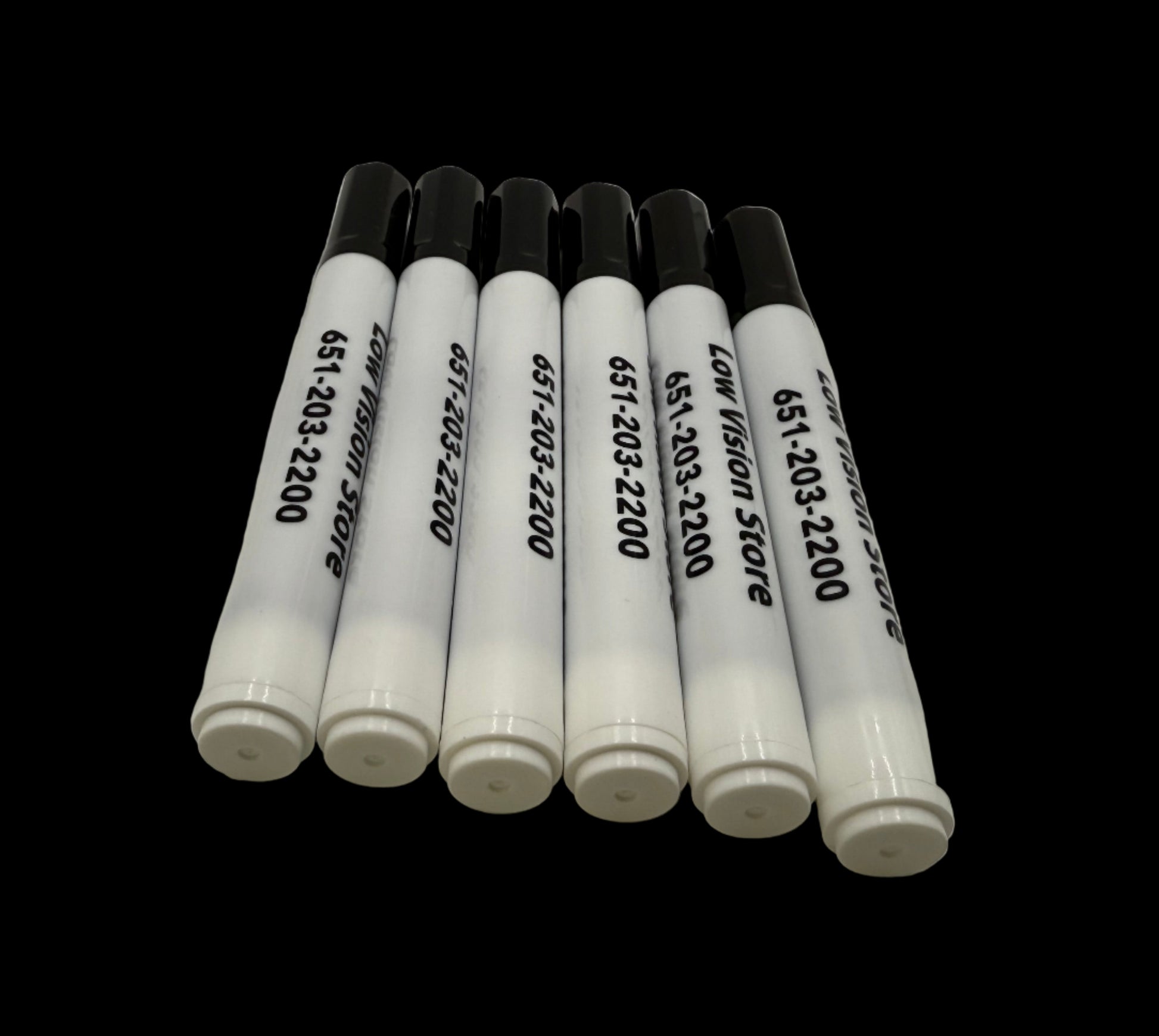 Set of white markers with black text on a white surface