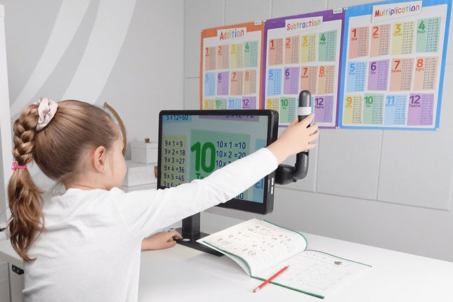A child using the Mirror Pad Pro 3-in-1 wireless magnifier to view educational materials on a computer screen.