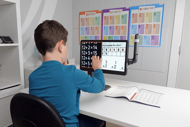 Child using Mirror Pad Pro, a 3-in-1 wireless magnifier, to view and solve math problems on a screen.