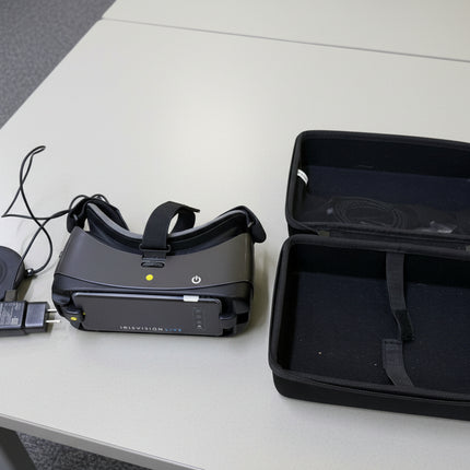 Used IRIS-Head Worn Video Magnifiers with case and charger on a table.