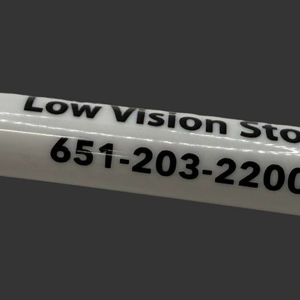 White marker with black cap on a white surface, displaying 'Low Vision Store' and phone number.