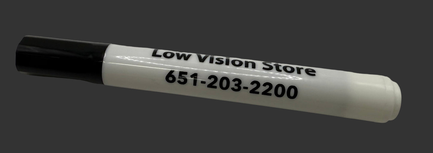 White marker with black cap on a white surface, displaying 'Low Vision Store' and phone number.
