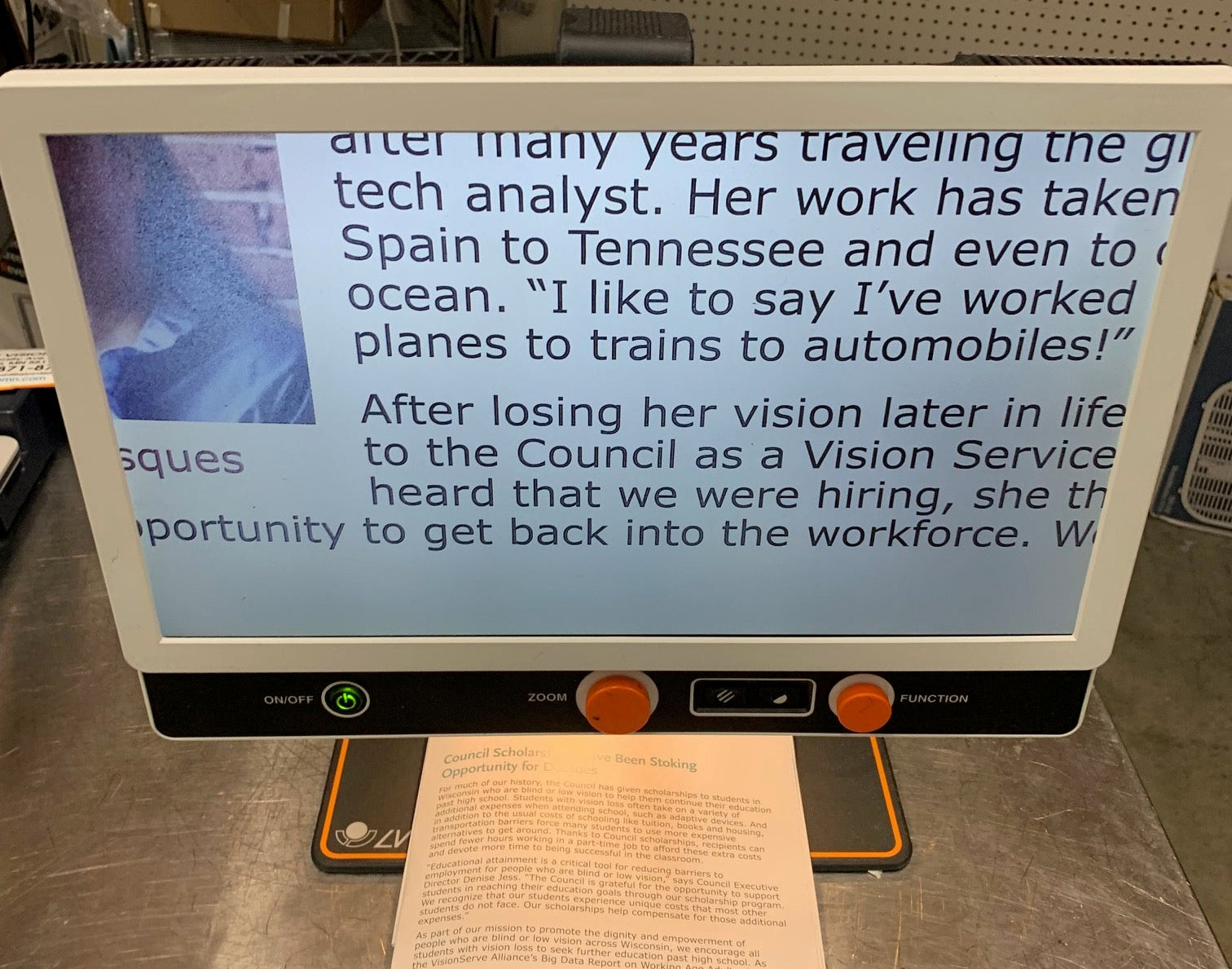 Large electronic display screen with text on a desk in an office setting