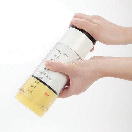 Adjustable measuring cup for low vision being used to measure ingredients effortlessly.