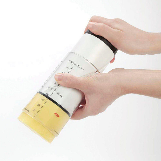 Adjustable measuring cup for low vision being used to measure ingredients effortlessly.