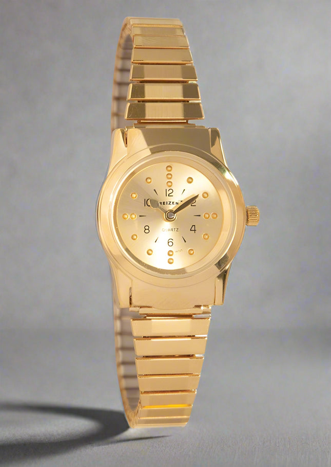 Braille gold-tone watch with expansion band, featuring a gold face and black numerals for tactile time-telling.
