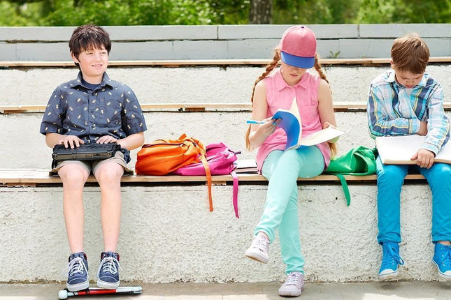 Kids using school supplies, including a Braille note taker tablet for education and learning activities.