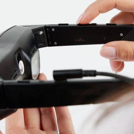 Close-up of eSight Go low-vision headset being held, showcasing its design and functionality for low vision assistance.