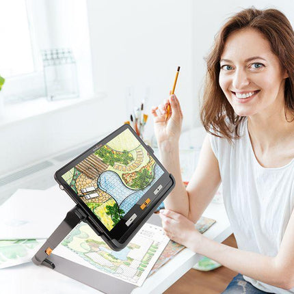 Woman using the Explore 12 portable video magnifier for low vision to read and create art.