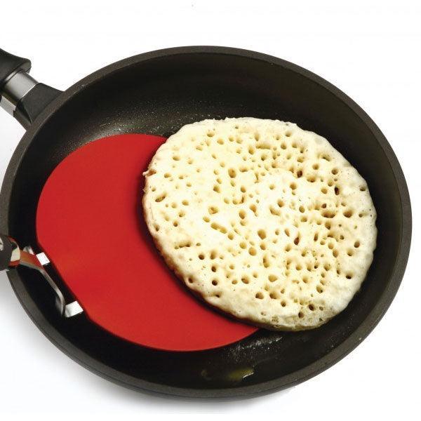 Grip-EZ Flexible Pancake Turner in use flipping a pancake in a non-stick pan.