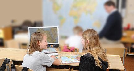 Students engaged in learning with a map and a video magnifier in a classroom setting.