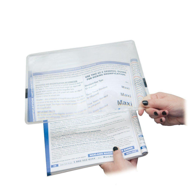 User demonstrating 2x page magnifier over reading material for enhanced visibility and clarity.