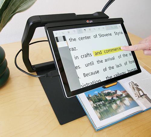 MagniLink TAB tablet solution for distance viewing in use with a book on a tabletop.
