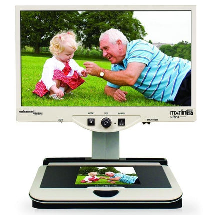 Merlin 24" ultra – Full HD Video Magnifier displaying vibrant images of a child and an elderly man outdoors.