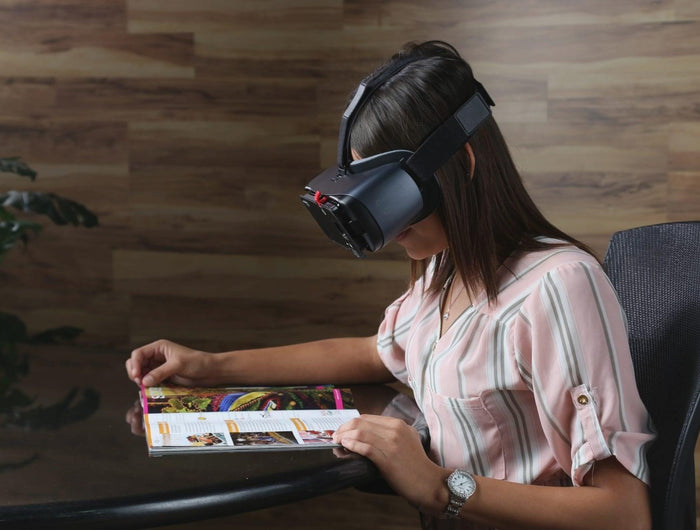 Woman using the Patriot View Point hands-free magnification device to read a magazine.
