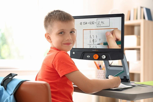 Child using a Reveal 16 full HD digital video magnifier for learning at home.