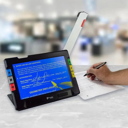 RUBY 10 portable video magnifier for low vision displaying a contract with a person writing.