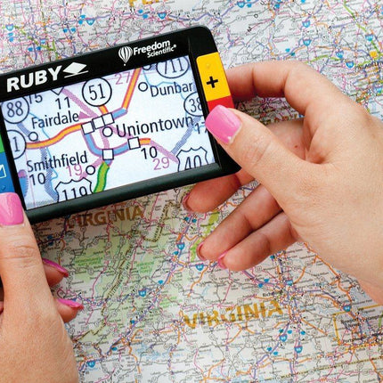 Person using the RUBY 4.3" portable video magnifier to view a map for navigation.