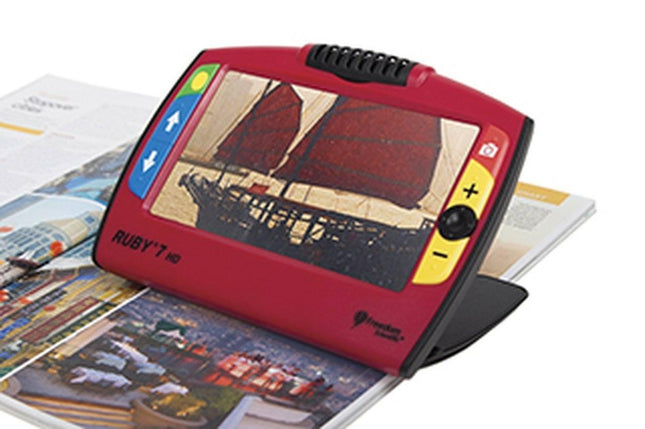 RUBY 7 HD portable video magnifier displaying an image of a ship on a magazine.