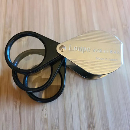 Folding Pocket Magnifier with three lenses offering 4x to 12x magnification in a compact design.