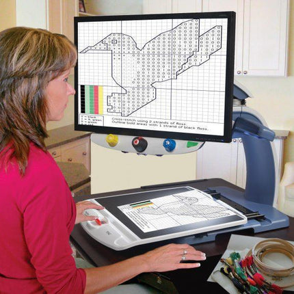 Woman using Topaz XL HD 24" Desktop Video Magnifier for easy viewing and crafting activities.