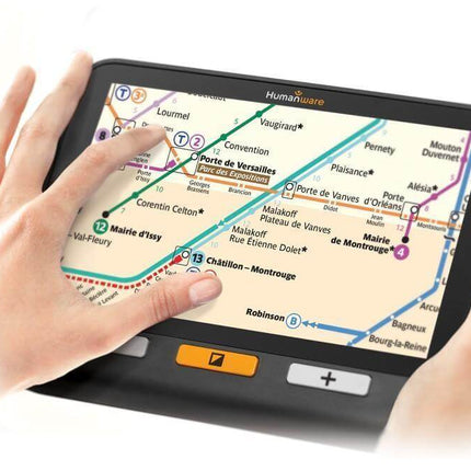 Hand using USED Explore 8 handheld electronic magnifier to view a map with touchscreen navigation features.