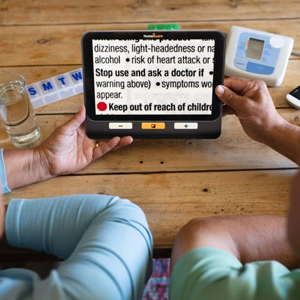 Two people using the Explore 8 handheld electronic magnifier to read text and instructions clearly.