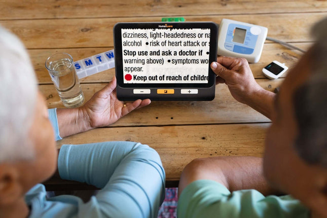 Two people using the Explore 8 handheld electronic magnifier to read text and instructions clearly.