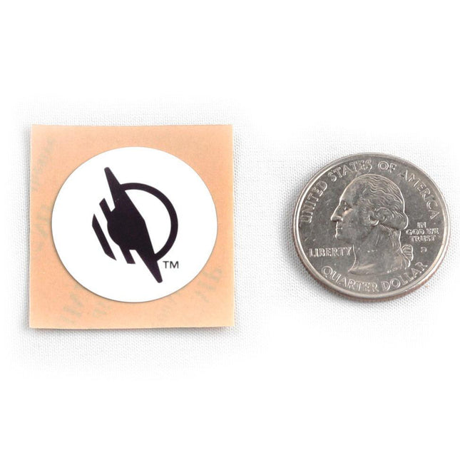Wireless WayTag stickers displayed next to a quarter for size comparison.